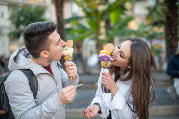 istock Young couple enjoying ice cream cones outdoors in urban setting 2191683087