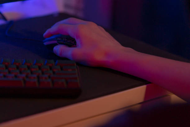 istock A hand on a Gaming Mouse with a Keyboard in a dim background 2191685054