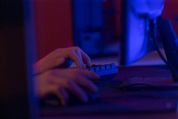 istock Hands Typing on Keyboard in Dimly Lit Background with Blue Lighting 2191685545