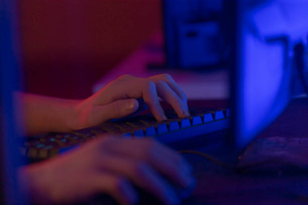 istock Hands Typing on Keyboard in Dark Ambient Background Lighting 2191685680