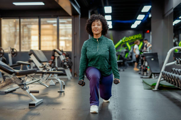 istock Focused Woman Engaged in Lunge Exercise with Dumbbells 2191687024