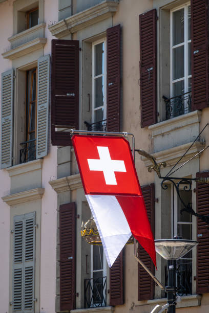 istock Swiss flag hangs outside building with shutters 2191688141
