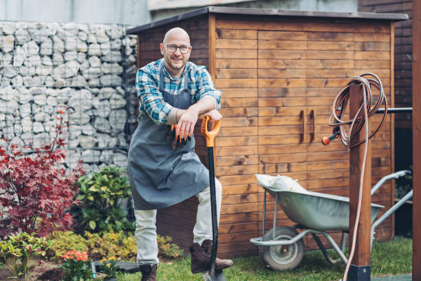 istock Smiling gardener leaning on a spade in the back yard 2191691236