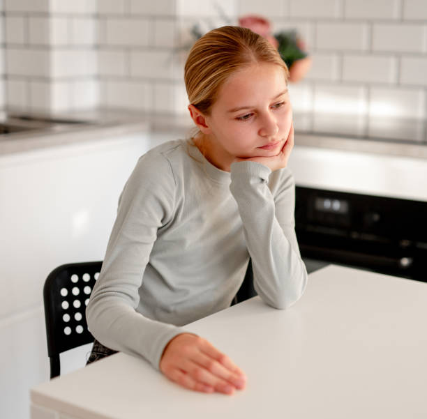 istock Cute Little Girl Sitting In Kitchen At Home 2191691821