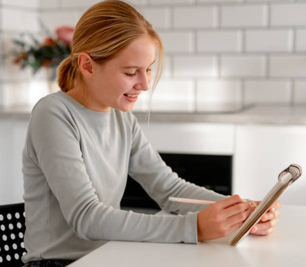 istock Happy Cute Little Girl With Notebook At Home 2191691830