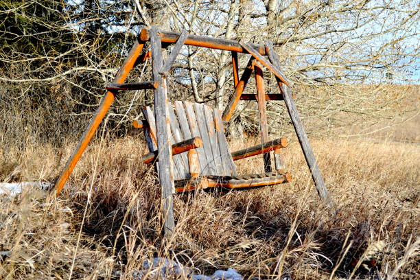 istock Abandoned bench swing on rural farm 2191705546