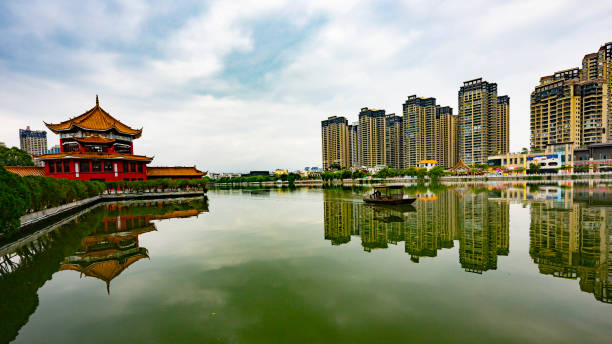 Buddhist temple with a bridge over the south-lake and skyscrapers in the reflection in  South China
