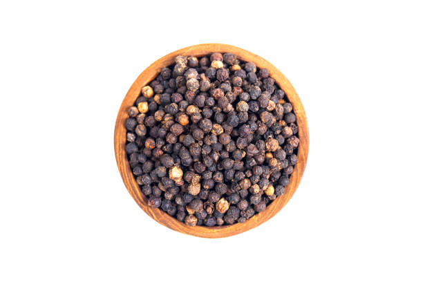 istock Black peppercorns (black pepper) in a wooden bowl isolated on a white background 2191708986