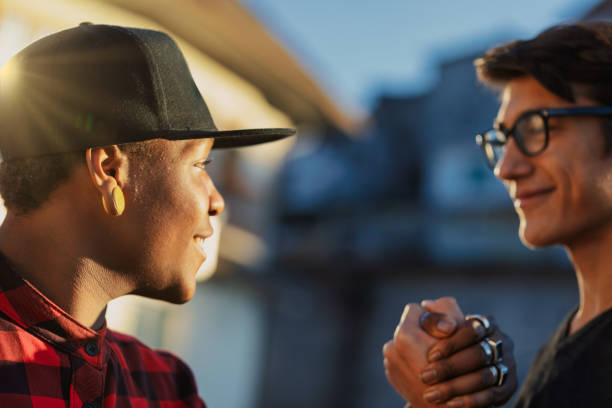 istock Two young men shaking hands in friendship and respect at sunset 2191710150
