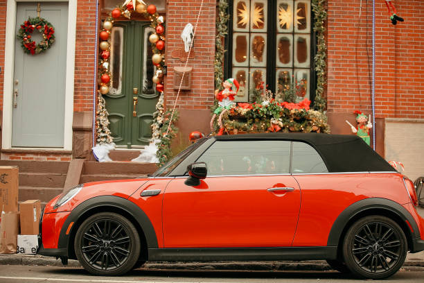 A red car is parked outside a brick house with a green door and window with Christmas decorations on Christmas Day in Philadelphia, Pennsylvania, USA December 25, 2024