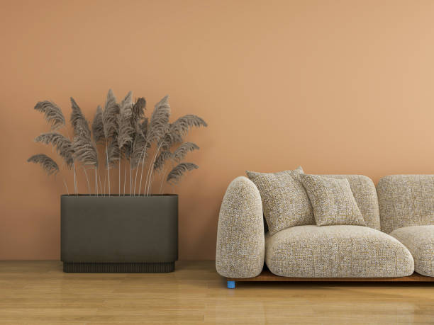 istock A modern living room featuring a warm terracotta wall, a cozy textured sofa, a large potted pampas grass plant, and a wooden floor, creating a relaxed and inviting atmosphere. 2191717572