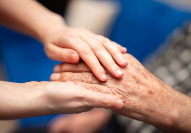 istock Young woman holding senior man hands, closeup 2191719099