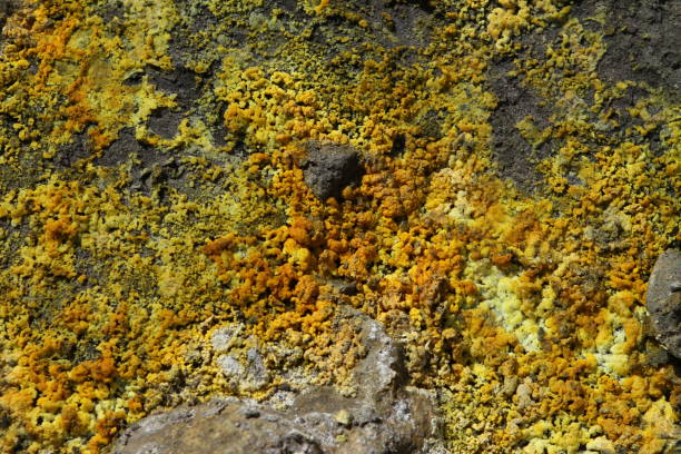 istock Orange and yellow sulphur on rocks with mud 2191719379