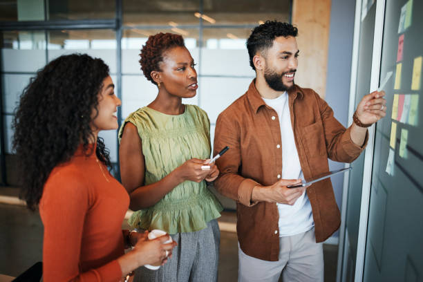 istock Team Brainstorming Ideas on Glass Whiteboard 2191720974