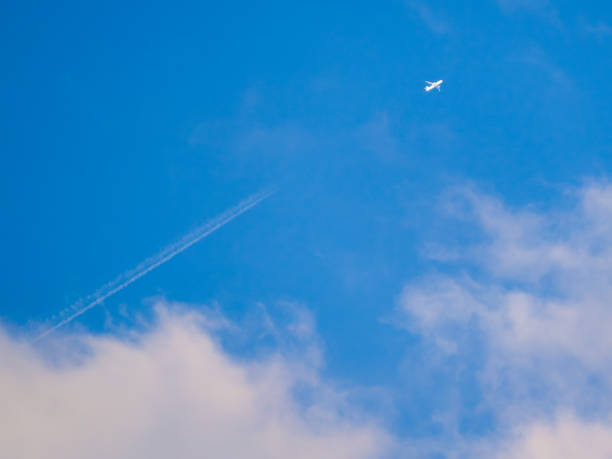 istock Passenger plane over white clouds in blue sky 2191724129