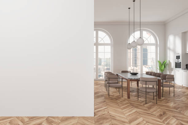 istock Modern dining room with a blank white wall on the left and a stylish dining table setup on the right. Large windows with a cityscape view. 3D Rendering 2191724293