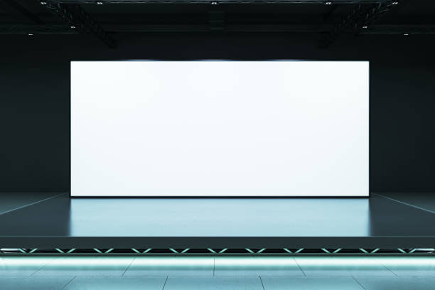 istock Blank white screen on an elevated stage in a dark room with modern lighting, perfect for exhibitions, displays, or presentations. 3D Rendering 2191725933