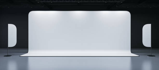 istock Empty exhibition booth with white backdrop and two curved panels in a dark interior hall. 3D Rendering 2191725939
