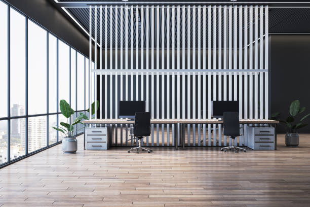 istock Modern executive office interior with desks, computers, plants, large windows, wooden flooring, and striped partition wall. 3D Rendering 2191726223