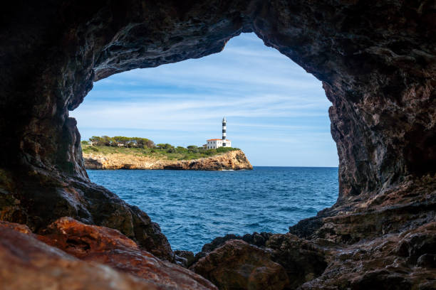 istock Lighthouse of portocolom seen from inside arc natural cave in mallorca 2191726357