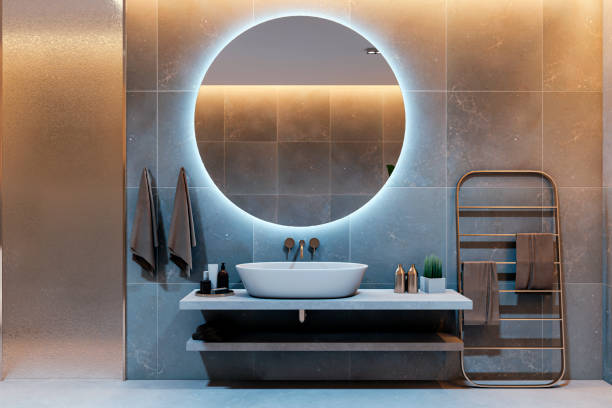 istock Modern bathroom interior with backlit round mirror, minimalist sink, and stylish towel rack on concrete walls at night. 3D Rendering 2191726600