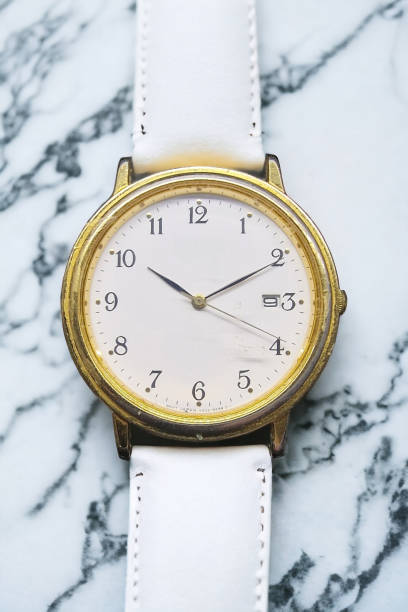 Vintage white round clock with brass frame showing time at 10:10