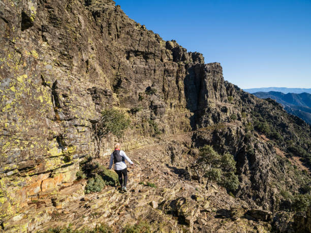istock Woman running through the mountains between cliffs in extreme terrain 2191728495