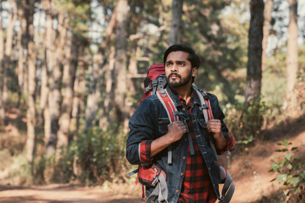 istock Travelers hiking through a forest with backpacks, exploring the wilderness and taking in the sights of nature as they walk. 2191732155