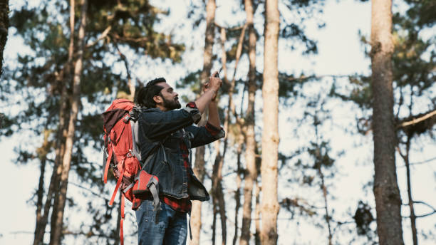 istock Travelers hiking through a forest with backpacks, exploring the wilderness and taking in the sights of nature as they walk. 2191732183