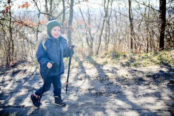 istock Young child smiling while hiking on forest trail, bundled up in blue winter jacket. 2191735160