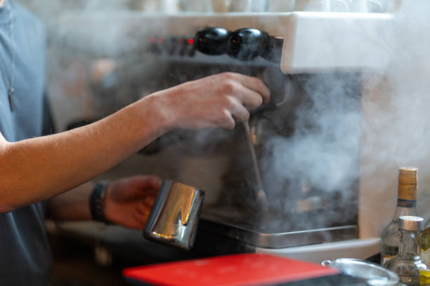 istock Barista steaming milk for coffee in cafe with espresso machine 2191735635