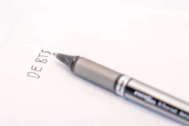 istock Silver Pen and Handwritten Word Debts on White Paper 2191739332