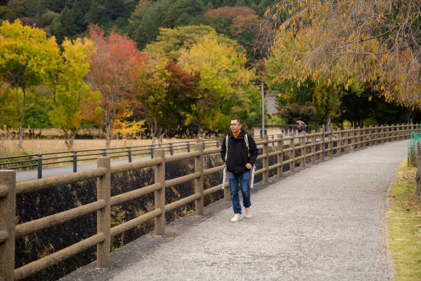 young man walking an explore  Saiko Iyashi-no Sato Nenba Fujikawaguchiko Town, Japan