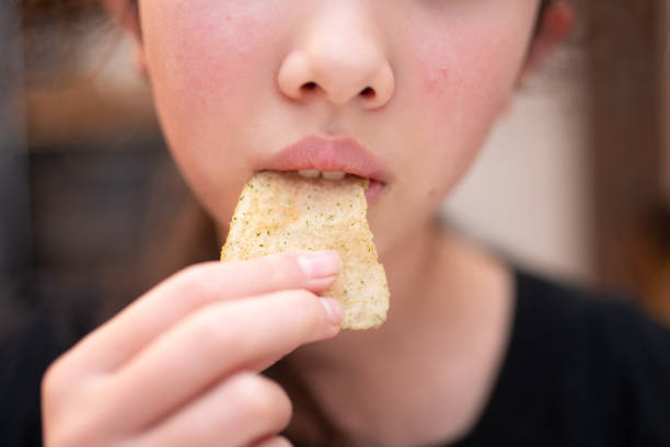 istock A child's mouth eating potato chips 2191742059
