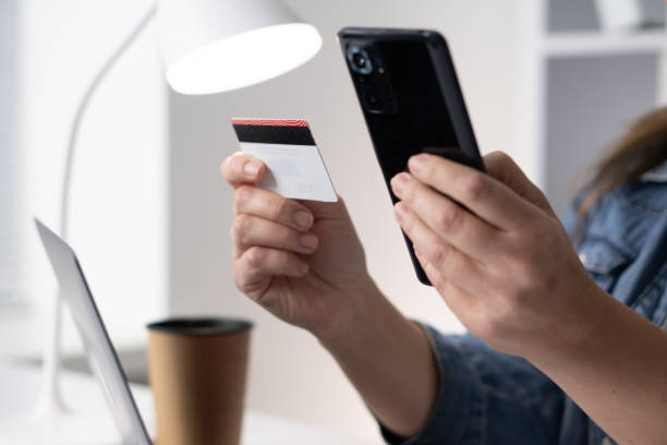 istock This image shows a closeup view of an individual holding a smartphone in one hand while gripping a credit card in the other, capturing the essence of modern transactions and consumer behavior 2191742342