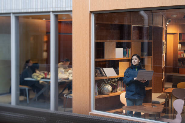 istock asian female working with laptop beside window in library 2191745454