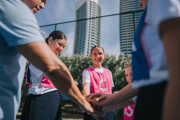istock Australian young netball team players huddling stacking hands before the game start with coach 2191745621