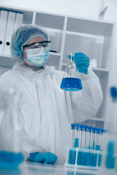 istock A scientist is meticulously conducting an experiment in a modern laboratory, carefully handling a flask filled with a vibrant blue liquid, ensuring accuracy and safety as part of the research process 2191747062
