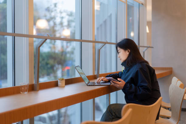 istock asian female working on laptop in office beside window 2191750959