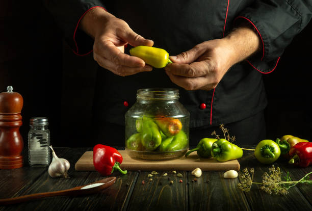 istock Hands skillfully prepare colorful peppers in a dimly lit kitchen. Fresh garlic, herbs, and spices enhance the artistry of cooking. A flavorful creation is on the way, highlighting culinary passion 2191755158