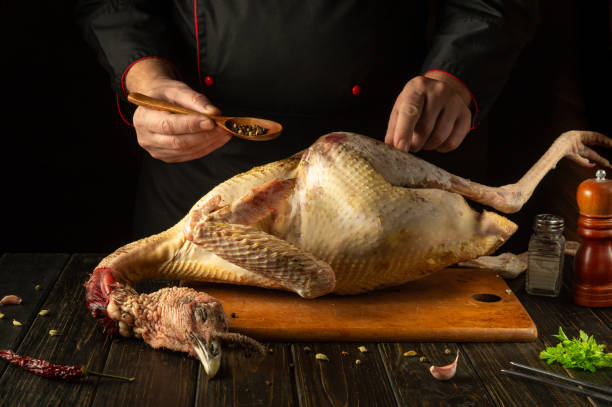 istock A chef seasons a fresh turkey with dry pepper in a cozy kitchen setting. The concept of preparing a national dish from a large bird for dinner. American cuisine 2191755309