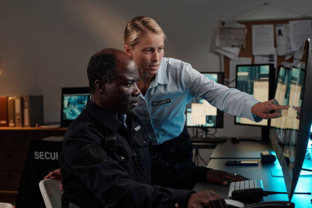 Female guard pointing at cctv on screen