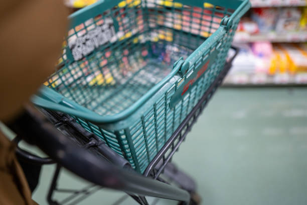 Empty shopping cart left abandoned in an urban environment. Concept of consumerism, waste, modern society, environmental pollution, and careless shopping habits.