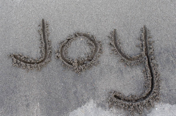 istock Message of Joy written in beach sand.  Upbeat hopeful message displayed. 2191765144