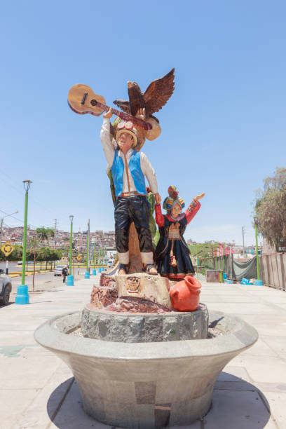 Moquegua, Peru - November 26, 2024 - Wooden sculptures created from century-old weeping fig trees felled for disease. Traditional clothing.