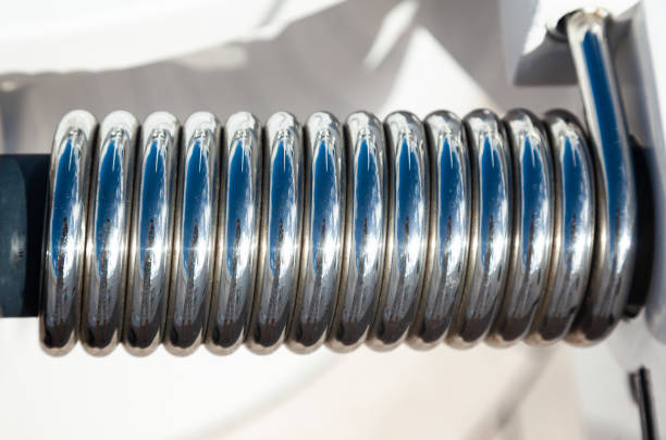 Stainless steel spring on the door hinge for quick closing, close-up.
