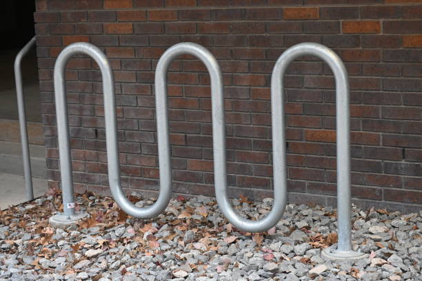 Row of metal arches for securing bicycles to in front of an old building.