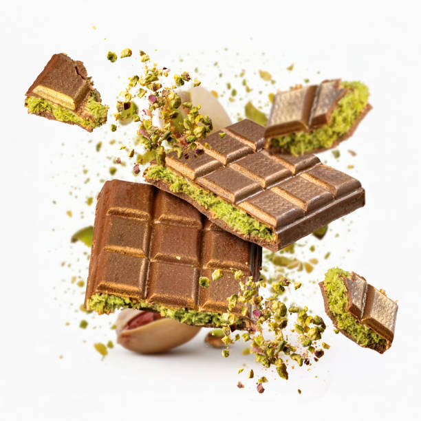 Tasty pistachio chocolate bars exploding on white background