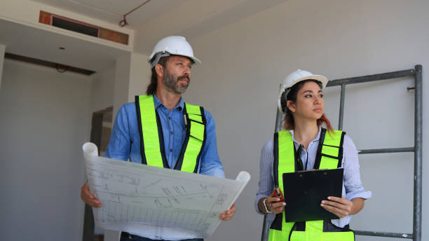 istock Caucasian civil construction engineers inspect homes for defects before handing them to clients. They examine the reconstructed construction site, checking every detail. 2191774573