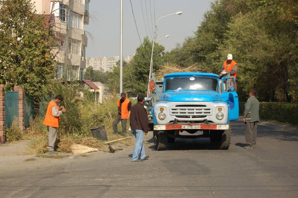 Street cleaners in Almaty with an old truck, captured during summer season.
